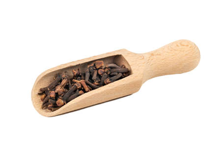 Dry cloves in a wooden scoop on a white backgroundの写真素材