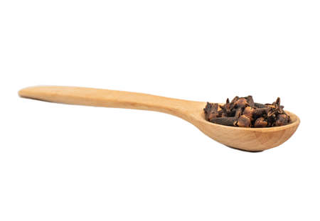 Wooden spoon with dry cloves isolated on white background closeupの写真素材