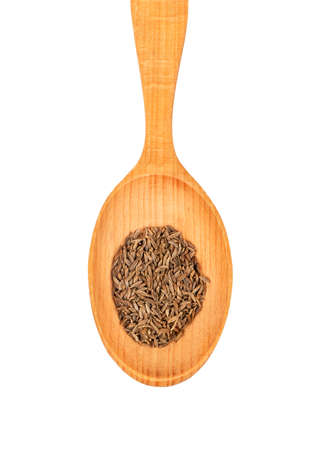 Wooden spoon with dry cumin closeup isolated on white background, top viewの写真素材