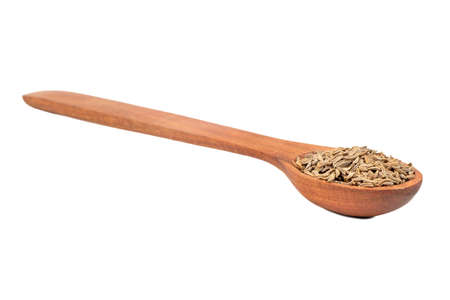 Spice dry cumin in wooden spoon closeup on white backgroundの写真素材