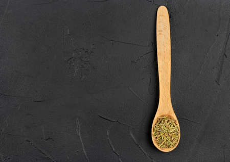 Small spoon with the dry rosemary on the empty concrete backgroundの写真素材