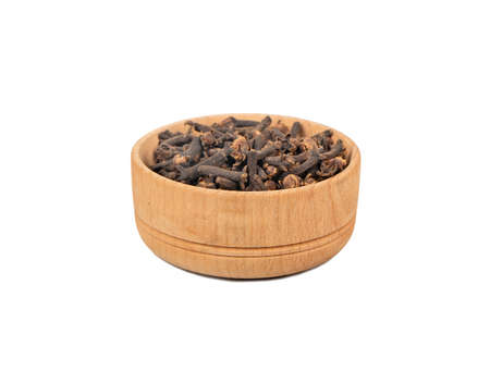 Dry cloves in wooden bowl isolated on white backgroundの写真素材