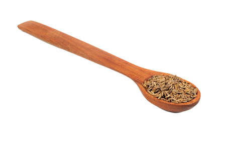 Spice dry cumin in wooden spoon closeup on white backgroundの写真素材