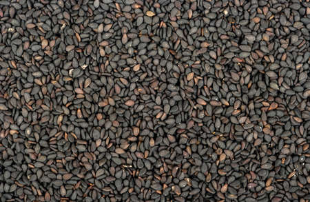 Background of scattered black sesame seeds closeupの写真素材