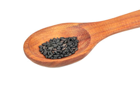 Wooden spoon with black sesame seeds closeup on white backgroundの写真素材