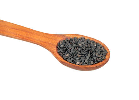 Wooden spoon with black sesame seeds closeup on white backgroundの写真素材