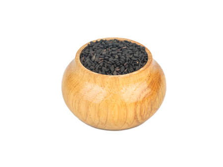 Black sesame in wooden container isolated on white backgroundの写真素材