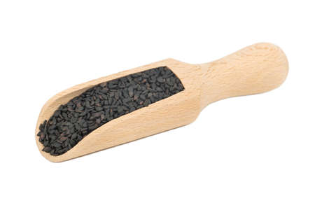 Black sesame in wooden scoop isolated on white backgroundの写真素材