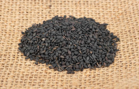 Pile of black sesame seeds closeup on burlapの写真素材