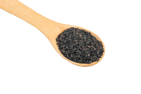 Small spoon with black sesame close up on white backgroundの写真素材