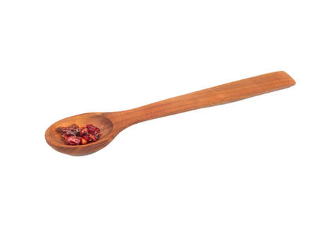 Dry red barberry in wooden spoon isolated on white backgroundの写真素材