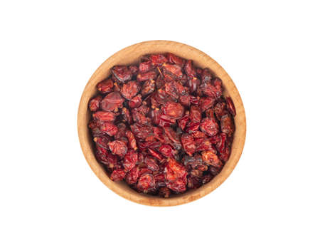 Dry barberry in wooden bowl on white background, top viewの写真素材
