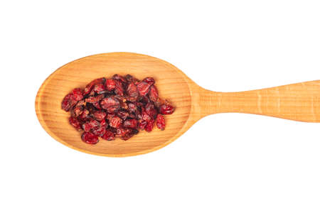 Dry barberry berries in wooden spoon close up on white background, top viewの写真素材
