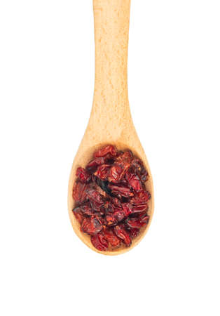 Dry barberry in a small wooden spoon isolated on white background closeup, top viewの写真素材