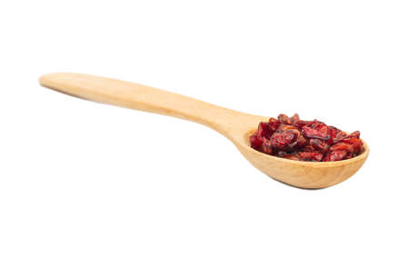 Dry barberry in a small wooden spoon isolated on white backgroundの写真素材