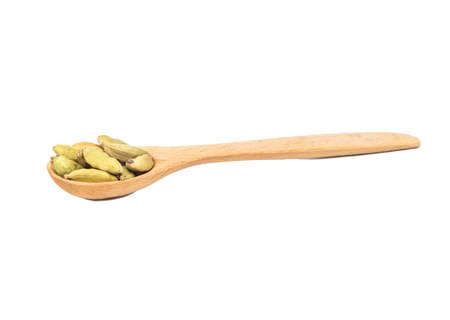 Green cardamom in wooden spoon isolated on white backgroundの写真素材