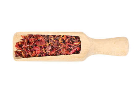 Wooden scoop with pieces of dry red pepper on white background, top viewの写真素材