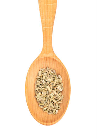 Dry fennel in a large wooden spoon closeup on white backgroundの写真素材