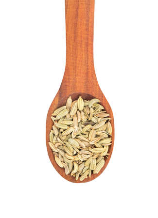 Dry fennel grains in wooden spoon on white background, top viewの写真素材