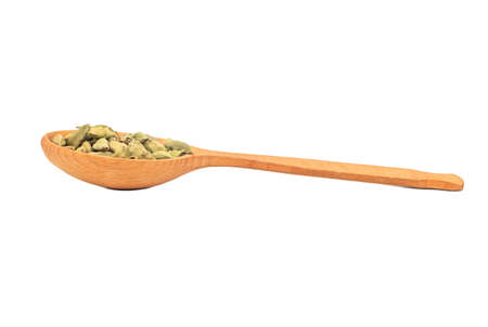 Large wooden spoon with dry cardamom isolated on white backgroundの写真素材