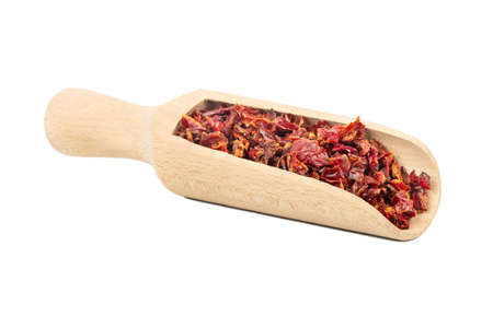 Wooden scoop with pieces of dry red pepper on white backgroundの写真素材