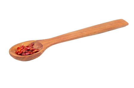 Pieces of dry red pepper in a wooden spoon isolated on a white backgroundの写真素材