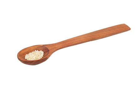 Dark wooden spoon with sesame seeds on white backgroundの写真素材