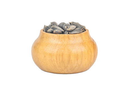 Sunflower seeds in a shell and a wooden container on a white backgroundの写真素材