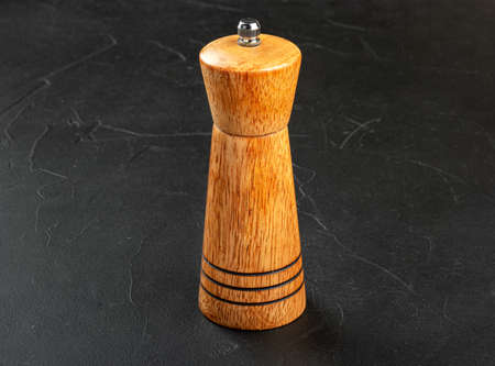 Wooden pepper pot on dark concrete backgroundの写真素材