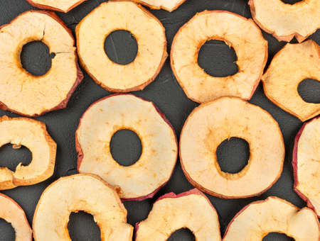 Scattered dry Apple chips on a dark concrete backgroundの写真素材
