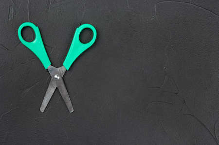 Scissors with plastic handle on empty dark background, top viewの写真素材