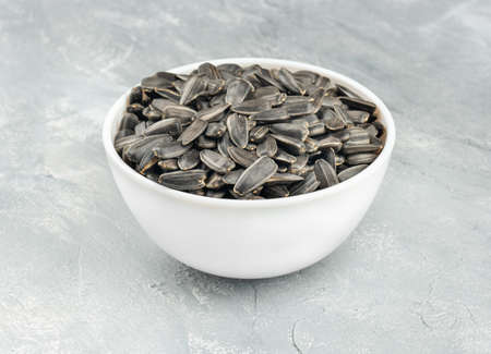 Ceramic bowl with sunflower seeds on a concrete backgroundの写真素材