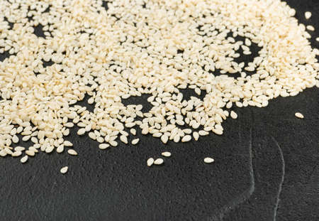 Scattered sesame seeds on a dark concrete backgroundの写真素材