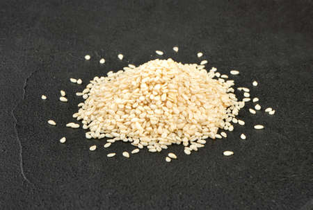 Pile of white sesame seeds on a dark concrete backgroundの写真素材
