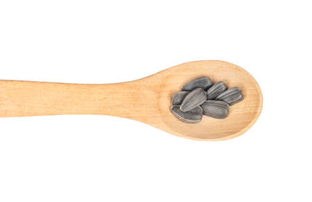 Sunflower seeds in a small wooden spoon on a white background, top viewの写真素材