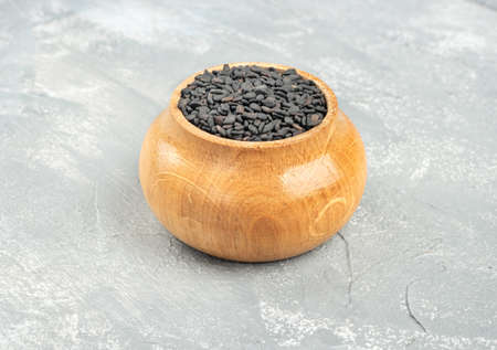 Black sesame in a wooden container on a light backgroundの写真素材