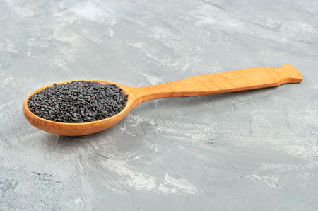 Black sesame in wooden spoon on concrete backgroundの写真素材