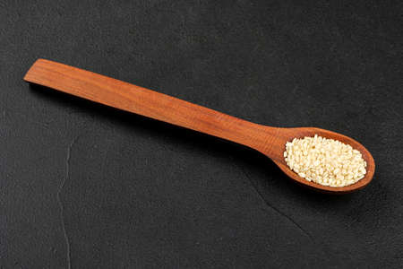 Small spoon with sesame seeds on dark backgroundの写真素材