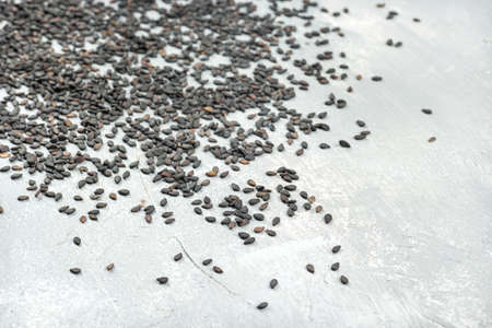 Scattered black sesame on a light concrete backgroundの写真素材