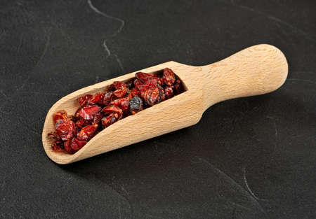 Dry barberry in a wooden scoop on a concrete backgroundの写真素材