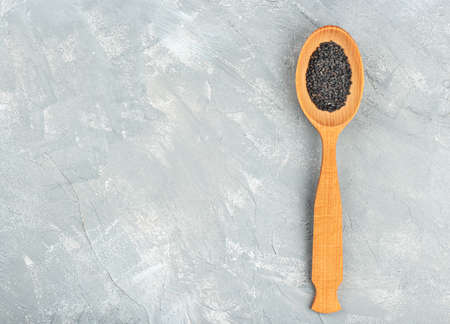 Wooden spoon with black sesame seeds on empty concrete backgroundの写真素材