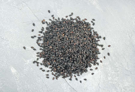 Pile of black sesame on a light concrete background, top viewの写真素材
