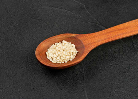 Small spoon with sesame seeds closeup on concrete backgroundの写真素材