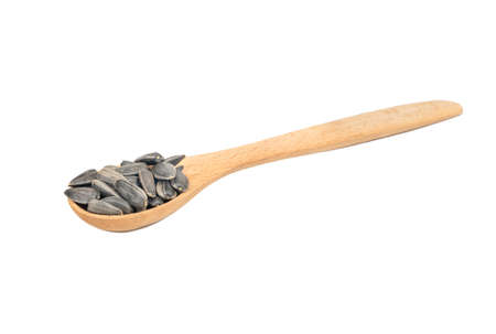 Small spoon with sunflower seeds on white backgroundの写真素材