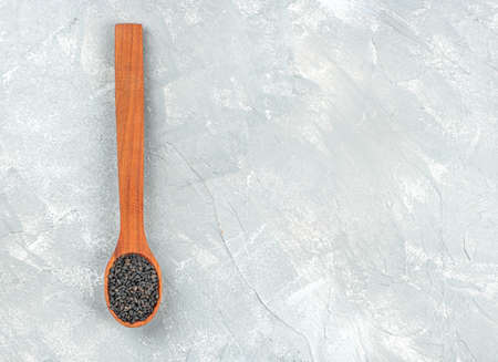 Wooden spoon with black sesame seeds on empty concrete backgroundの写真素材
