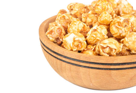 Piece of wooden bowl with popcorn in caramel on white backgroundの写真素材