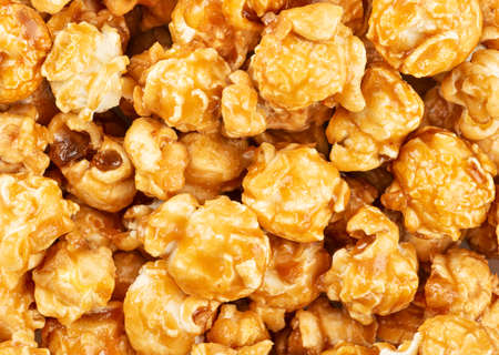 Background of scattered sweet popcorn in caramel closeupの写真素材