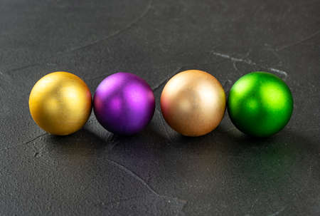 Four colorful Christmas balls on a dark concrete backgroundの写真素材