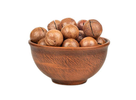 Macadamia nut in a ceramic bowl on a white backgroundの写真素材