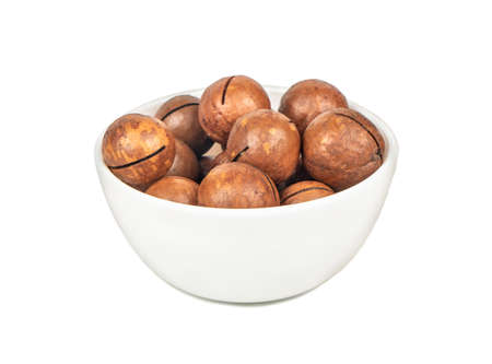 Macadamia nut in a ceramic bowl on a white backgroundの写真素材